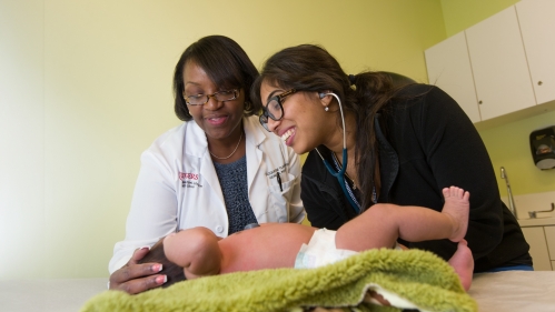 Care team members attend to an infant patient at the Chandler Center