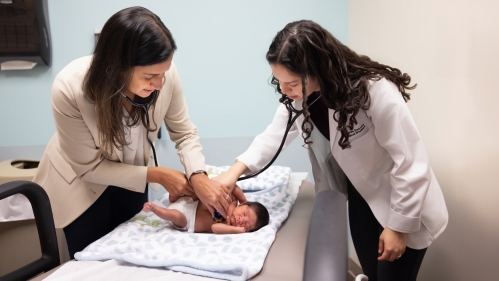 Doctors listen to an infant patient's heart and lungs