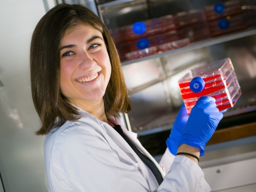 A researcher pulls sample trays out of a freezer in a lab
